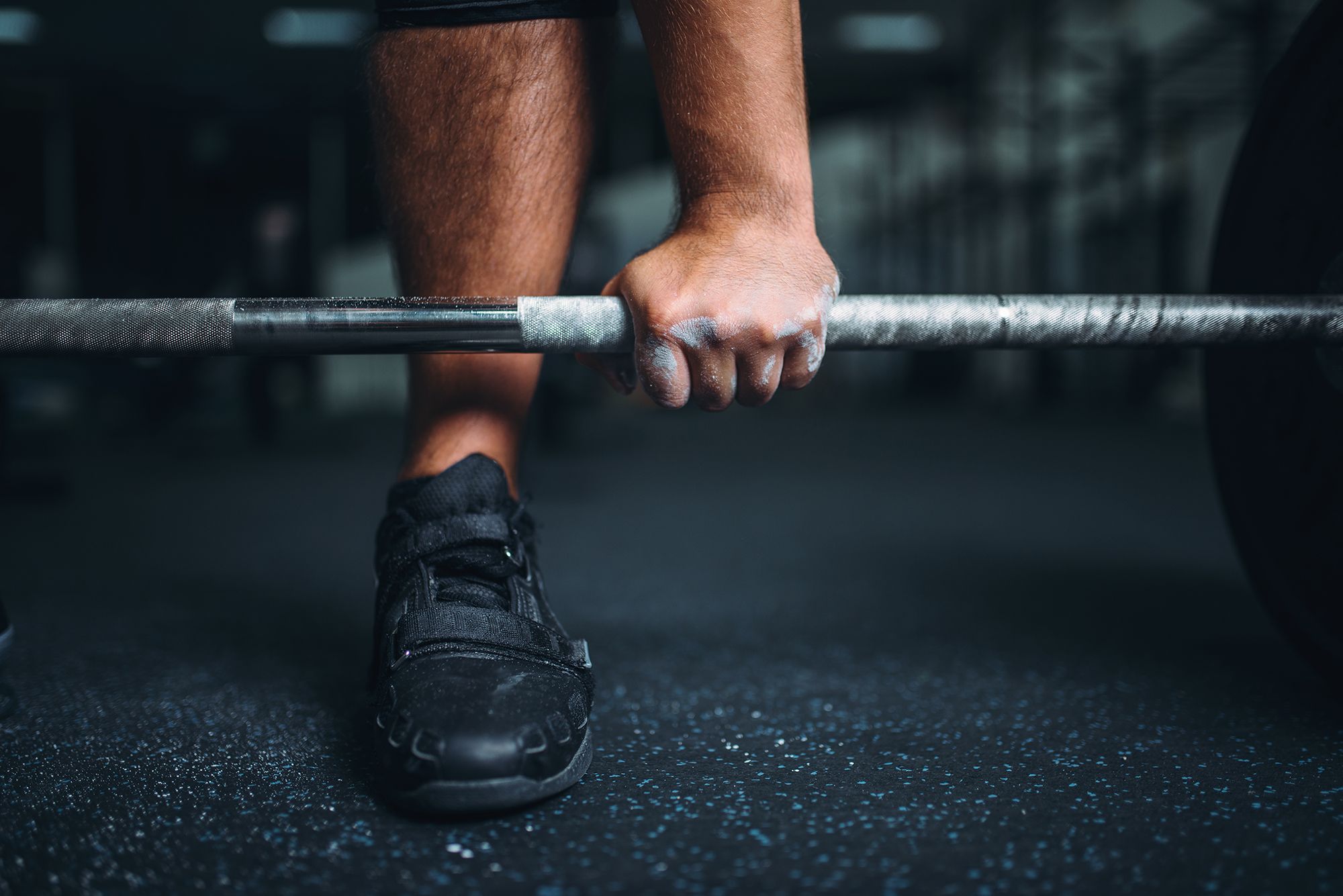 powerlifter prepares to deadlift a barbell