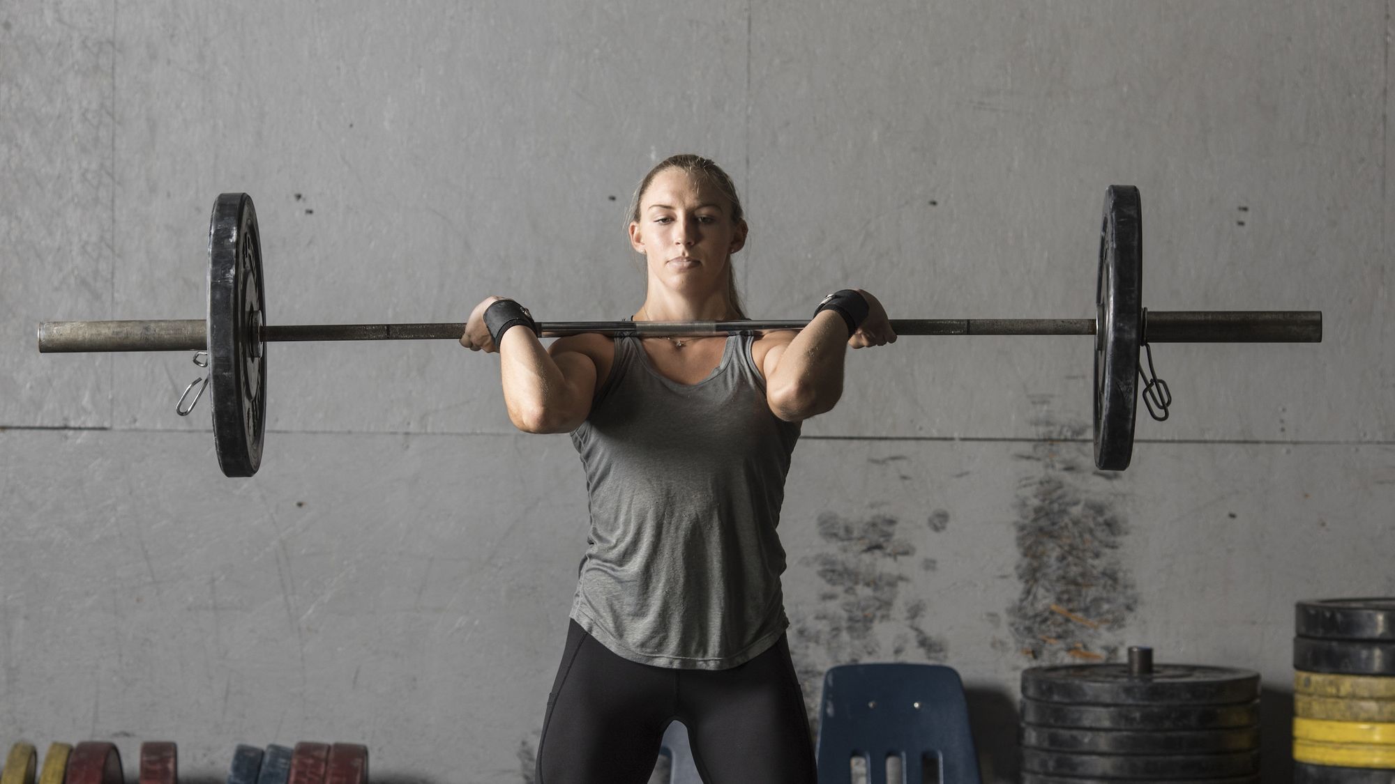 young female weight lifter training in gym