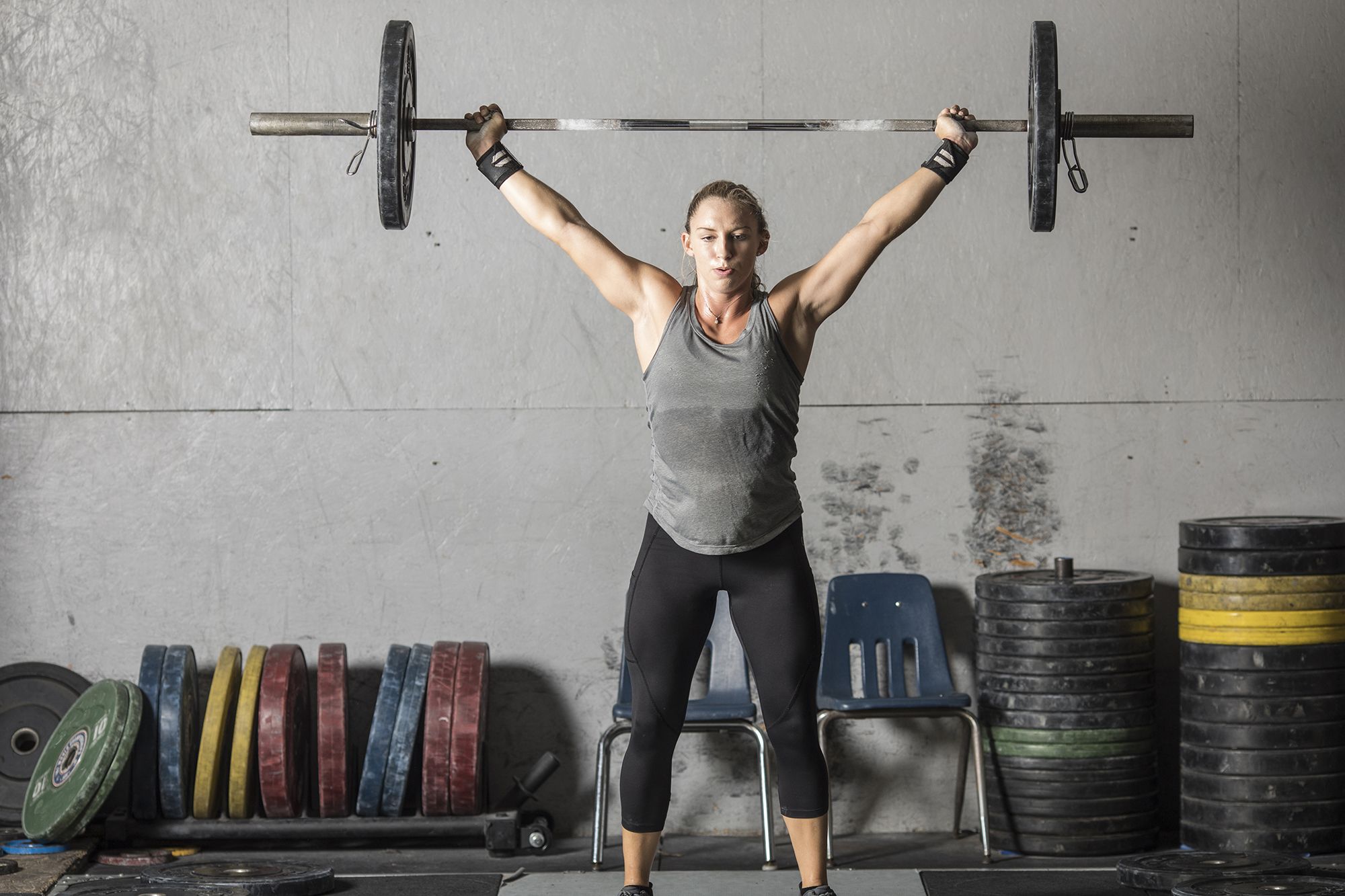 strong woman with heavy barbell over head